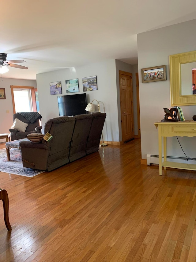 living room featuring light hardwood / wood-style floors, baseboard heating, and ceiling fan