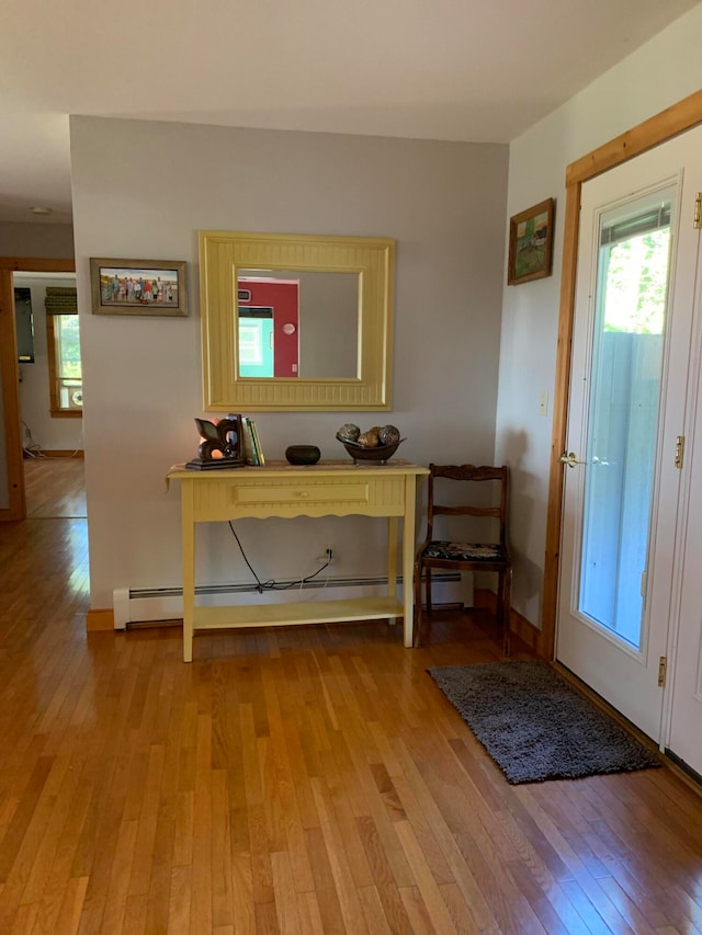 interior space with a baseboard heating unit and light hardwood / wood-style floors