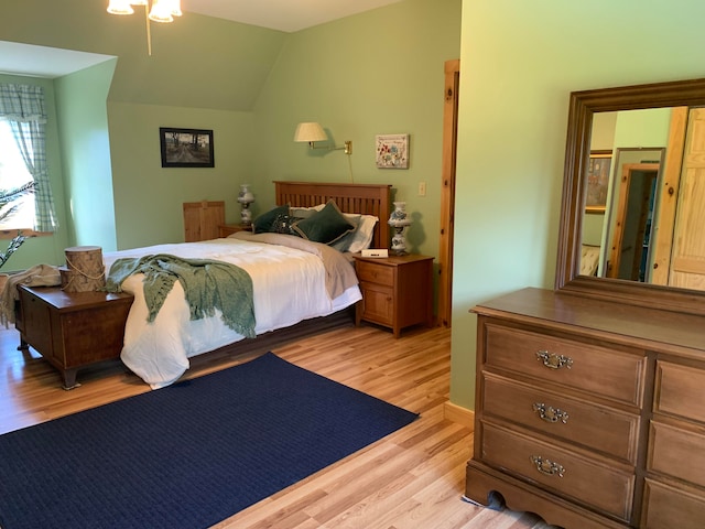 bedroom with lofted ceiling and light hardwood / wood-style floors