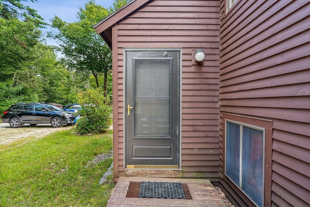 doorway to property with a lawn