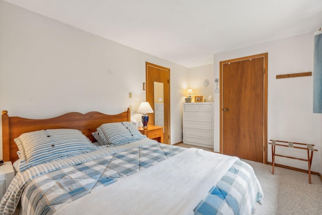 bedroom with baseboards, a closet, and light colored carpet