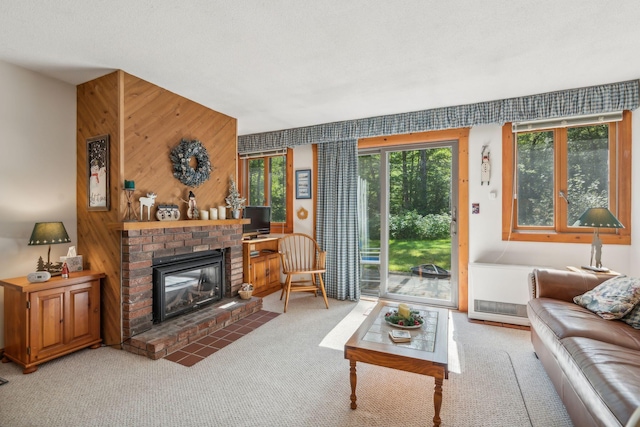 carpeted living room with a fireplace and wooden walls