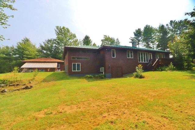 rear view of property featuring a lawn