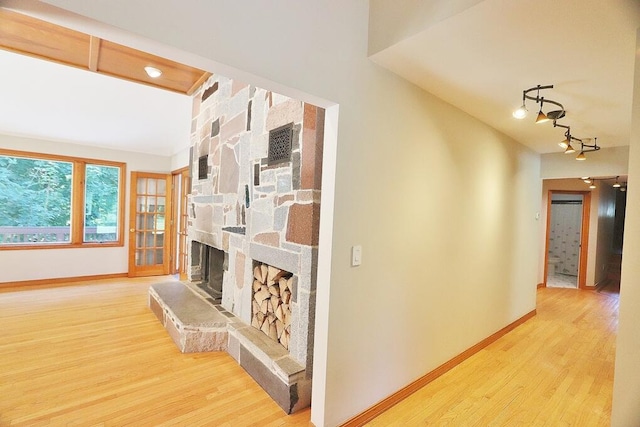 hall with track lighting and light hardwood / wood-style flooring