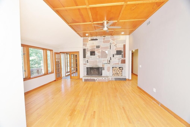 unfurnished living room featuring hardwood / wood-style floors, ceiling fan, a stone fireplace, and wooden ceiling