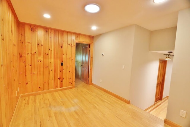 empty room featuring wood-type flooring and wooden walls