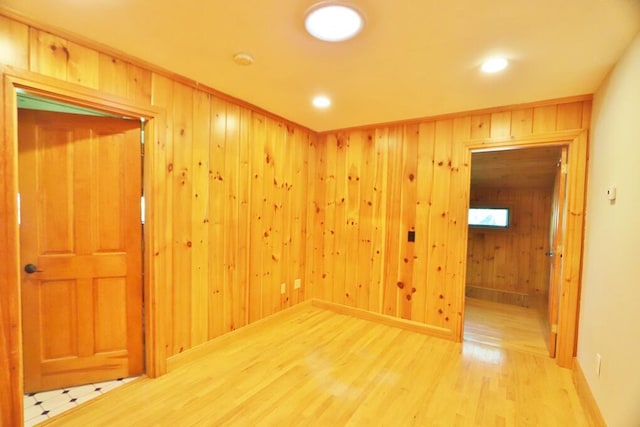 spare room featuring hardwood / wood-style flooring and wooden walls