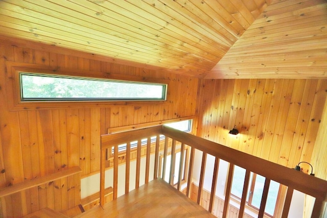 hall with a wealth of natural light, wooden ceiling, and wood walls