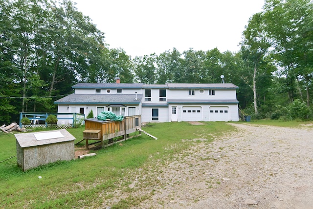 view of front of property with a wooden deck, a garage, and a front yard