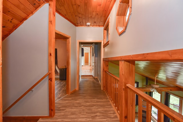 corridor featuring hardwood / wood-style flooring, baseboard heating, and wooden ceiling