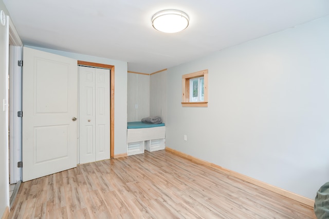 unfurnished bedroom featuring a closet and light wood-type flooring