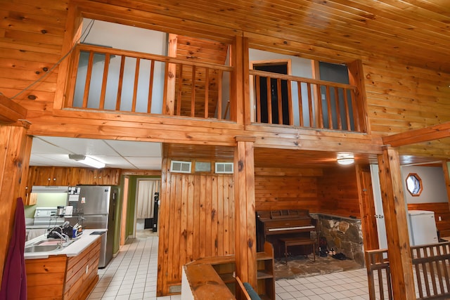 staircase with tile patterned flooring, wood walls, and sink