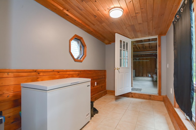 laundry room featuring wood ceiling, plenty of natural light, and light tile patterned floors