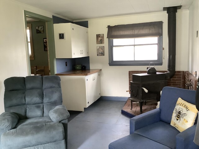 living room featuring concrete flooring and a wood stove