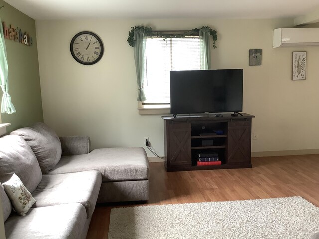 living room featuring a wall unit AC and hardwood / wood-style flooring