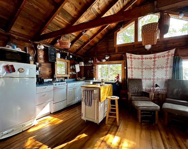 kitchen featuring white cabinets, light hardwood / wood-style flooring, plenty of natural light, white gas range, and fridge