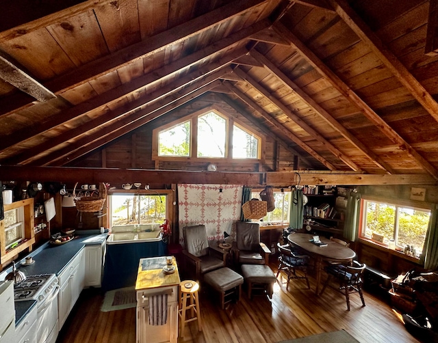 living room with wood-type flooring, vaulted ceiling with beams, wooden walls, and wood ceiling