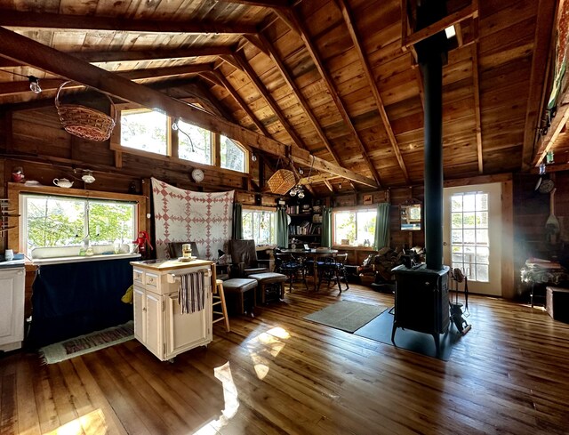 interior space featuring wood ceiling, a wood stove, wood-type flooring, and a center island