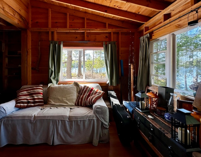 interior space with wood-type flooring, lofted ceiling with beams, wood walls, and wooden ceiling