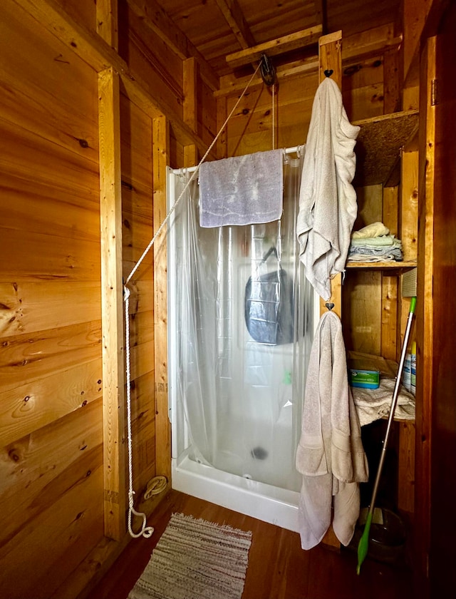 bathroom with wooden walls, hardwood / wood-style flooring, wooden ceiling, and curtained shower