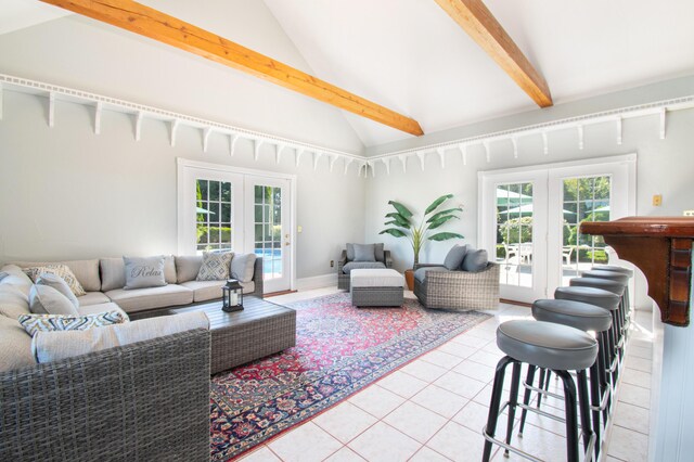 tiled living room with lofted ceiling with beams and french doors