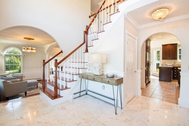 staircase with ornamental molding, a chandelier, and a baseboard radiator