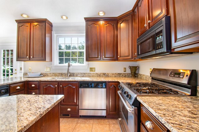 kitchen featuring ornamental molding, light tile patterned floors, stainless steel appliances, light stone counters, and sink