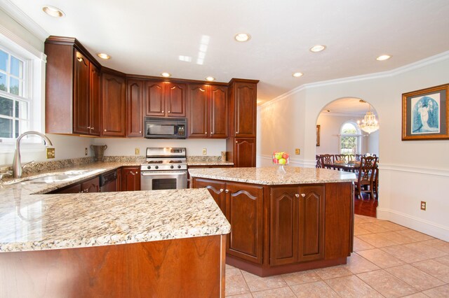 kitchen featuring light stone counters, a center island, stainless steel stove, and ornamental molding