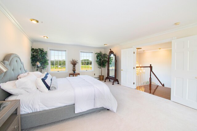 carpeted bedroom featuring crown molding and a notable chandelier