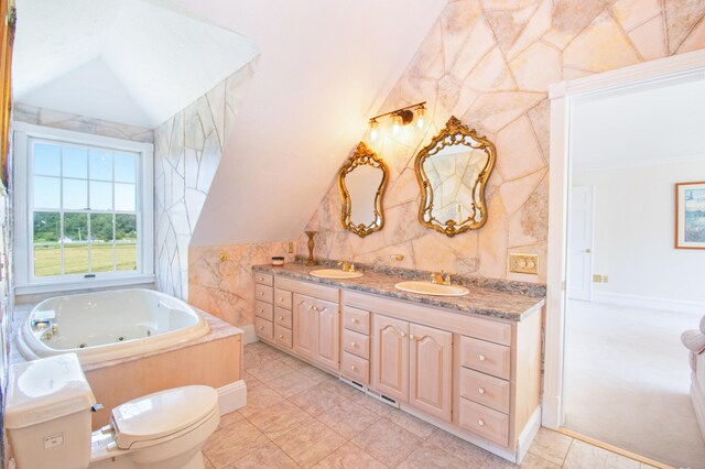 bathroom featuring vanity, lofted ceiling, a bathing tub, and tile walls