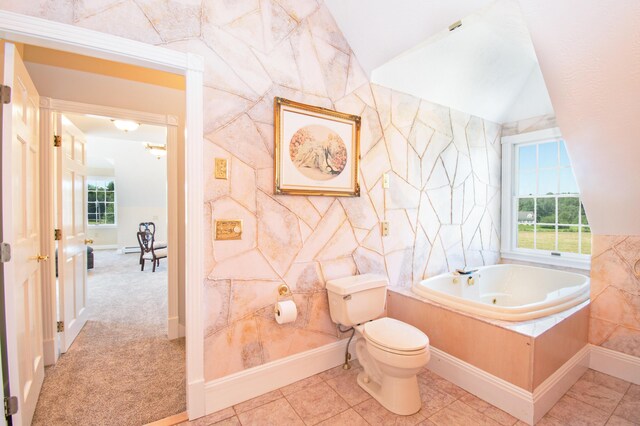 bathroom with lofted ceiling, plenty of natural light, toilet, and a relaxing tiled tub