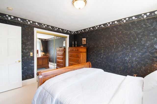 carpeted bedroom with a closet and a baseboard radiator