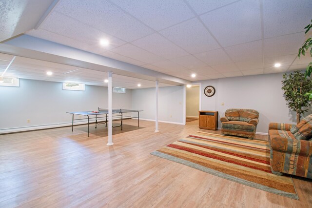 living room with light wood-type flooring and a paneled ceiling