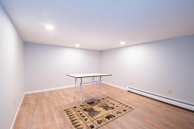 recreation room with a baseboard radiator and light hardwood / wood-style flooring