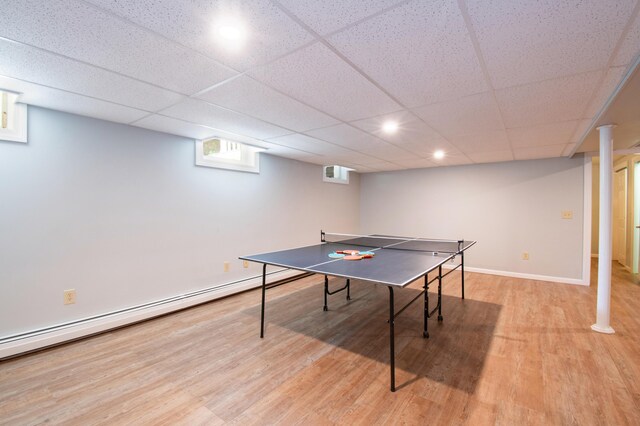 playroom with a baseboard heating unit, a paneled ceiling, and light hardwood / wood-style floors