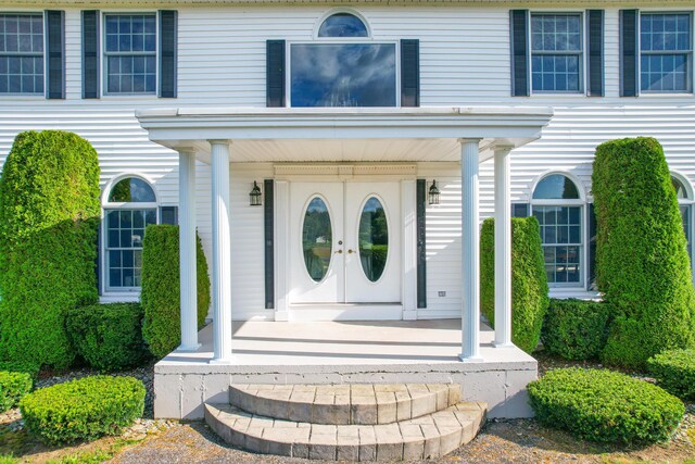 view of exterior entry featuring covered porch