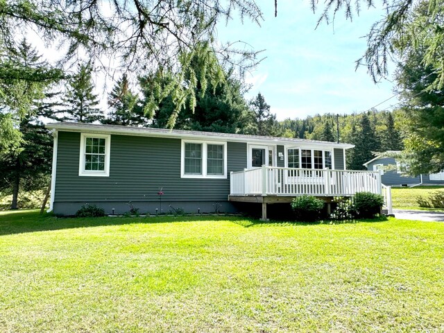 view of front of property with a wooden deck and a front yard