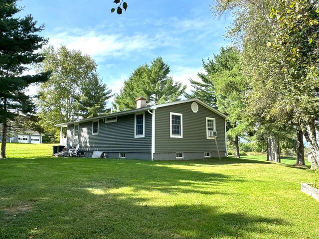 back of house featuring cooling unit and a lawn