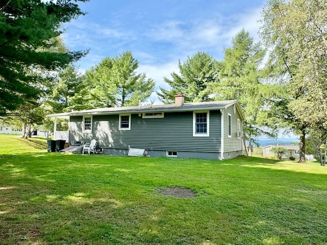 back of property with a lawn and a chimney