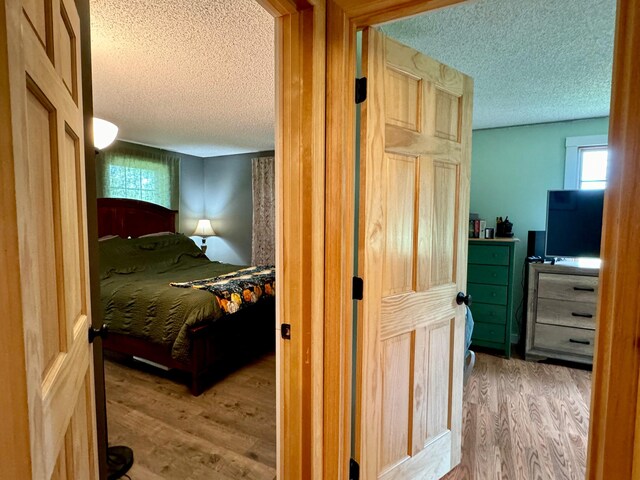 bedroom featuring a textured ceiling and light hardwood / wood-style floors