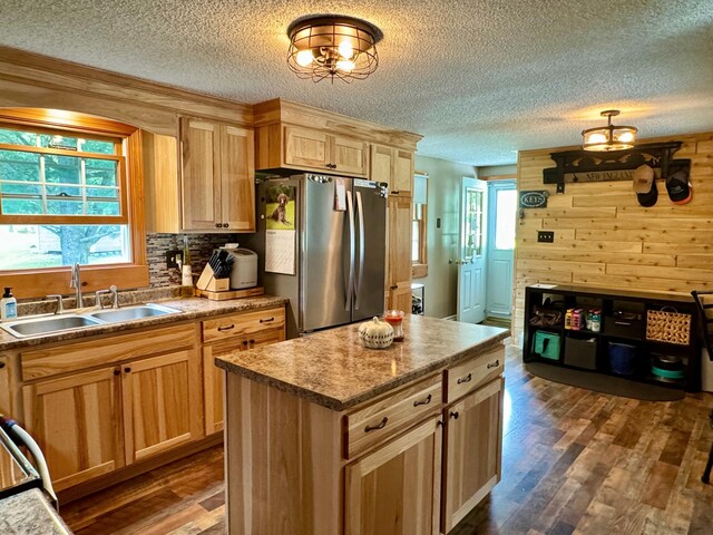 kitchen featuring a center island, dark hardwood / wood-style flooring, sink, stainless steel fridge, and a textured ceiling