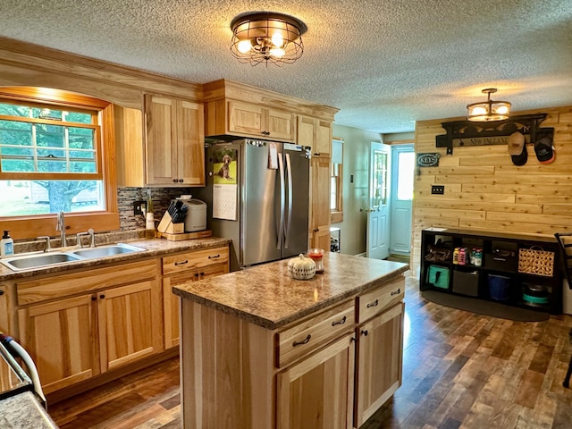 kitchen featuring decorative backsplash, wood walls, dark wood finished floors, a sink, and freestanding refrigerator