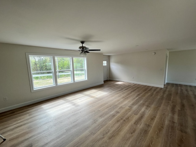 spare room featuring baseboards, ceiling fan, and wood finished floors