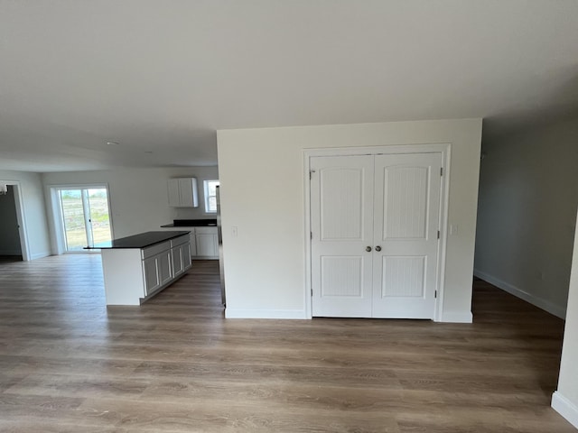 unfurnished living room featuring baseboards and light wood-style floors
