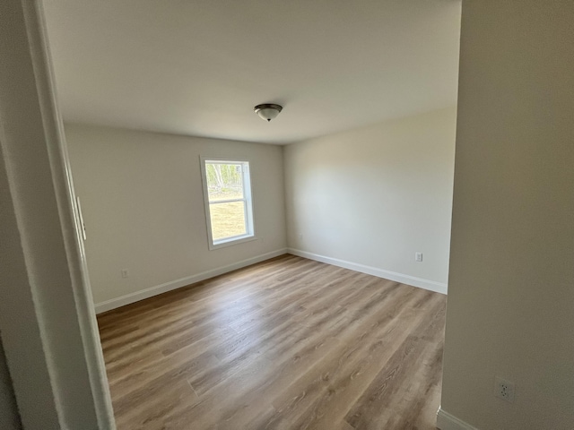 spare room with wood finished floors and baseboards