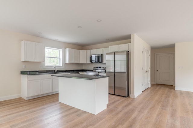 268 Merrill Rd, Levant, ME 04456 - kitchen featuring appliances with stainless steel finishes, white cabinets, dark countertops, and a center island