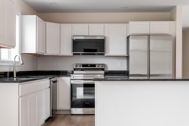 268 Merrill Rd, Levant, ME 04456 - kitchen with stainless steel appliances, white cabinetry, and dark stone counters