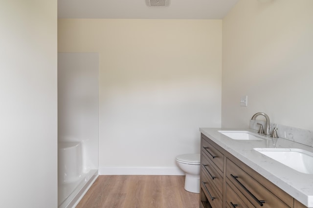 268 Merrill Rd, Levant, ME 04456 - full bathroom featuring wood finished floors, baseboards, double vanity, and toilet
