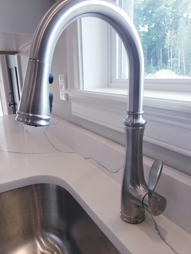 room details featuring light stone counters and sink