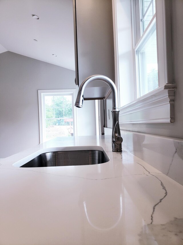 interior details featuring sink and light stone countertops